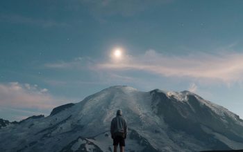 Wallpaper Man Standing on Grass Field Overlooking Mountain