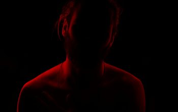 Wallpaper A Woman in a Dark Room with a Red Light