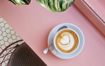 Wallpaper Cup of Coffee on Saucer with Teaspoon on Pink Tabletop