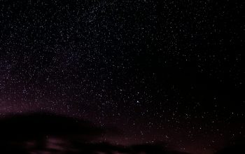 Wallpaper The Night Sky is Filled with Stars and Clouds