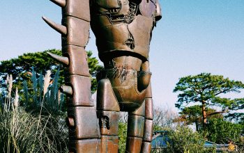 Wallpaper Robot Statue Surrounded by Flowers in Daylight