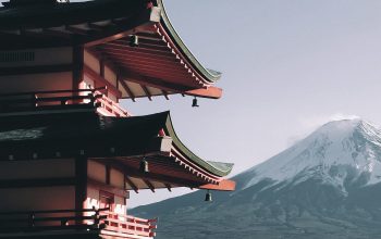 Wallpaper A Tall Pagoda with a Mountain in the Background
