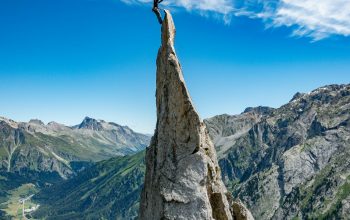 Wallpaper Person Standing on Rock Formation During Daytime