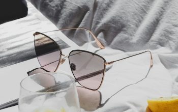 Wallpaper A Pair of Sunglasses on a Bed