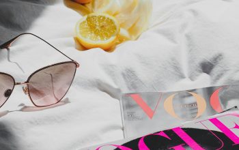 Wallpaper A Pair of Sunglasses and a Book on a Bed