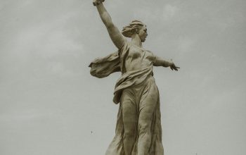 Wallpaper Man Holding Stick Statue During Daytime