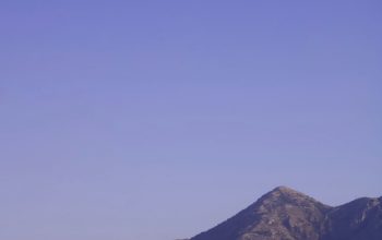 Wallpaper A Mountain Range with a Moon in the Sky