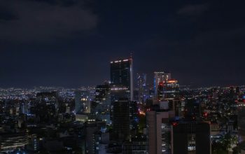 Wallpaper A Night View of a City with Tall Buildings