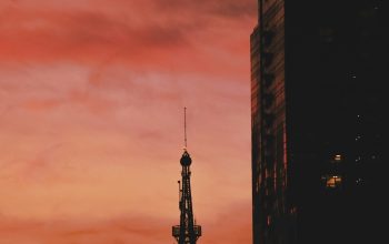 Wallpaper A Tall Tower Piercing Cloudy Skies