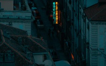 Wallpaper A City Street at Night with a Neon Sign