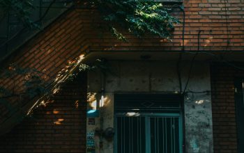 Wallpaper A Tall Brick Building with a Green Door
