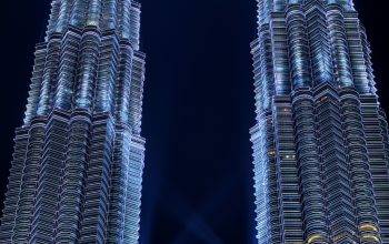 Wallpaper Two Tall Buildings Lit Up at Night
