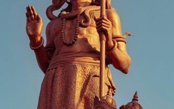 Wallpaper A Statue on Top of a Building with a Sky Background