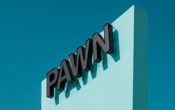 Wallpaper A Pawn Shop Sign Against a Bright Blue Sky