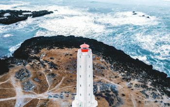 Wallpaper Bird’s Eye View of a White Lighthouse Tower near the Ocean