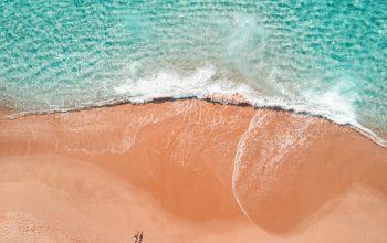 Wallpaper Aerial Photography of Two People Sunbathing on the Seashore