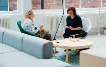 Wallpaper Two Women Sitting on Sofa Chairs Inside House