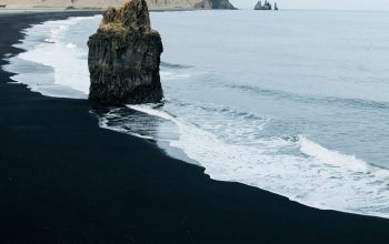 Wallpaper Brown Monolith Rock on Seashore