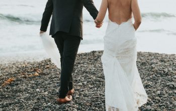 Wallpaper Groom and Bride Walking on Stone Near Body of Water