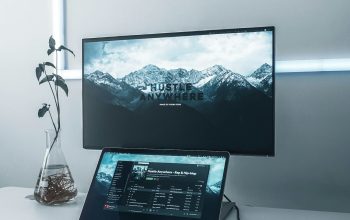 Wallpaper Turned-On Flat Screen TV, MacBook Pro, Earbuds, and Mouse