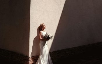 Wallpaper Woman Standing Beside Wall Holding Flowers