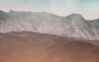 Wallpaper Person Standing on Rock Near Snow-Covered Mountain
