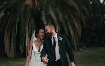 Wallpaper A Newly Married Couple Walking Through a Field