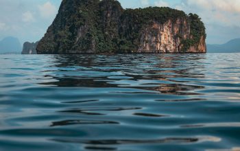 Wallpaper Brown Rock Formation on Blue Sea Water During Daytime