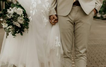Wallpaper Man in Gray Suit Jacket and Woman in White Wedding Dress Holding Bouquet of White Flowers