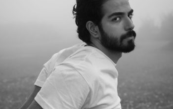 Wallpaper A Man with a Beard Standing in a Field