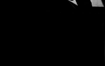 Wallpaper A Silhouette of a Man Leaning Against a Wall