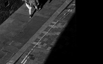 Wallpaper A Man Riding a Skateboard Down a Sidewalk