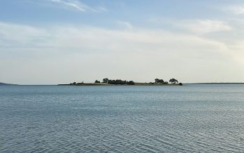Wallpaper A Body of Water with a Small Island in the Distance