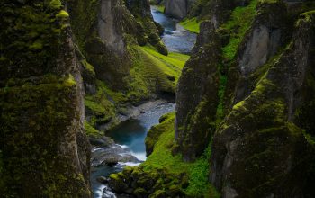 Wallpaper A River Running Between Rocky Cliffs