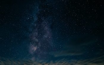 Wallpaper A Starry Night Sky with a Tree and House Silhouette