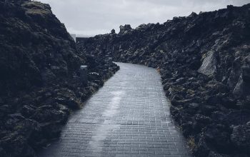 Wallpaper A Stone Pathway Between Rocky Cliffs