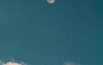 Wallpaper A Full Moon Over a Mountain