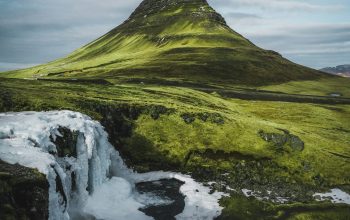 Wallpaper A Mountain with a Small Waterfall