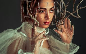 Wallpaper A Woman in a White Dress Holding Up Branches