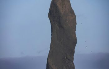 Wallpaper A Tall Rock Sticking Out of the Ocean