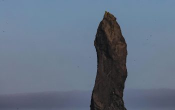 Wallpaper A Large Rock Sticking Out of the Ocean