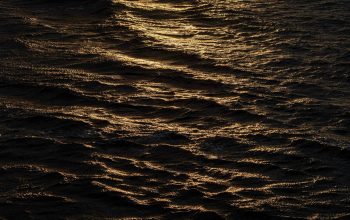 Wallpaper The Sun is Setting Over the Ocean Water