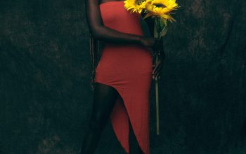 Wallpaper A Woman in a Red Dress Holding a Bouquet of Yellow Flowers