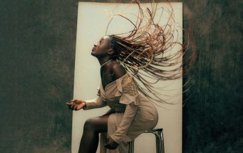 Wallpaper A Woman Sitting, Hair Blowing in the Wind