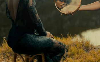 Wallpaper A Woman Sitting on a Stool Holding a Mirror