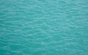 Wallpaper A Boat Floating on Top of a Large Body of Water
