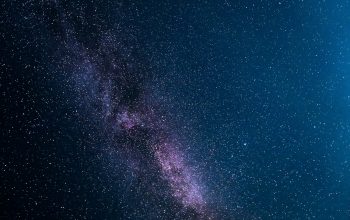 Wallpaper A Bright Blue Light Shines Brightly in the Night Sky