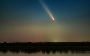 Wallpaper A Comet in the Night Sky Above a Lake