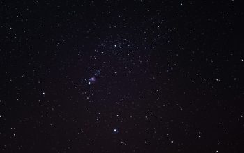 Wallpaper A Night Sky with Stars and a Few Clouds