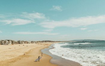Wallpaper Man Standing with Surfboard Facing Seashore